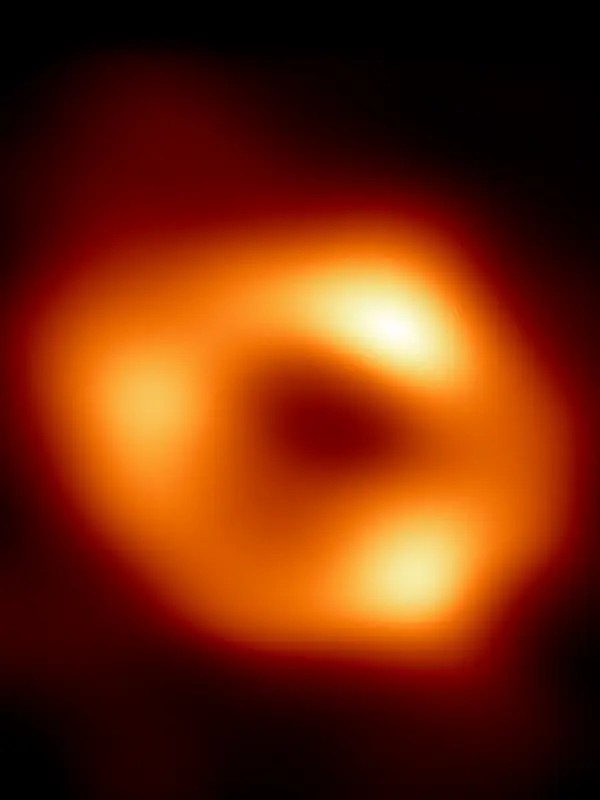 The image shows a dark central region (called a shadow) surrounded by a bright ring-like structure.