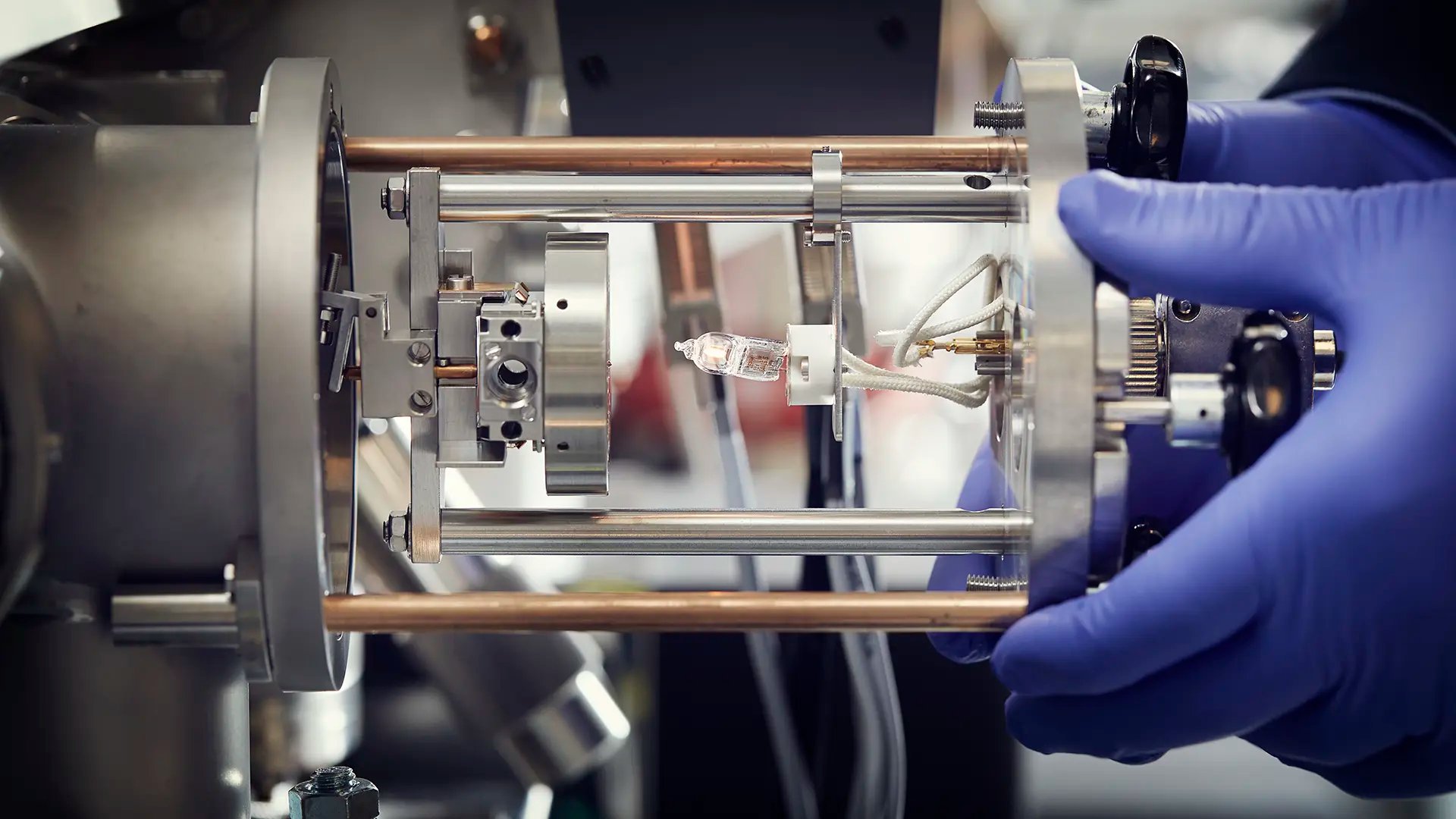 Bilden visar hur ett prov, som sitter på den runda metalldisken, förs in i instrumentet nanoSIMS