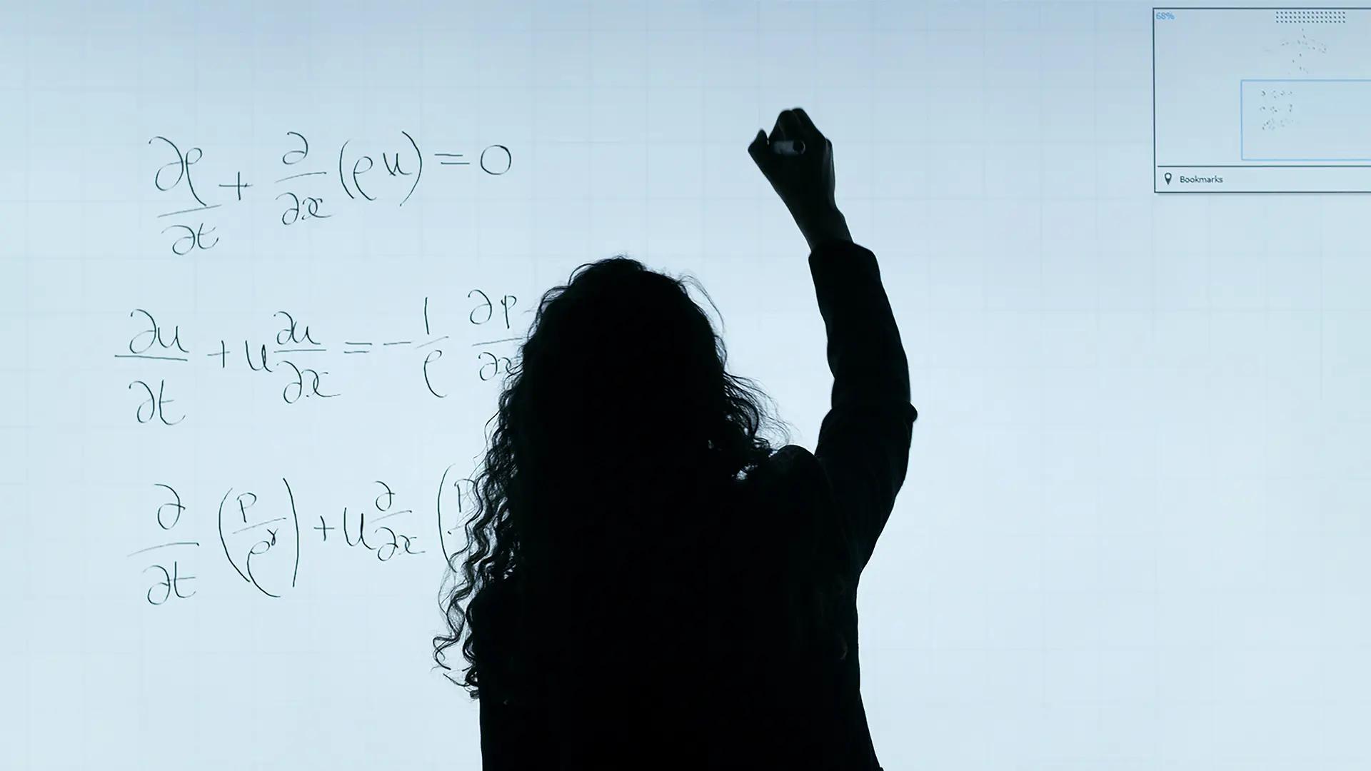 Person doing calculations on whiteboard.