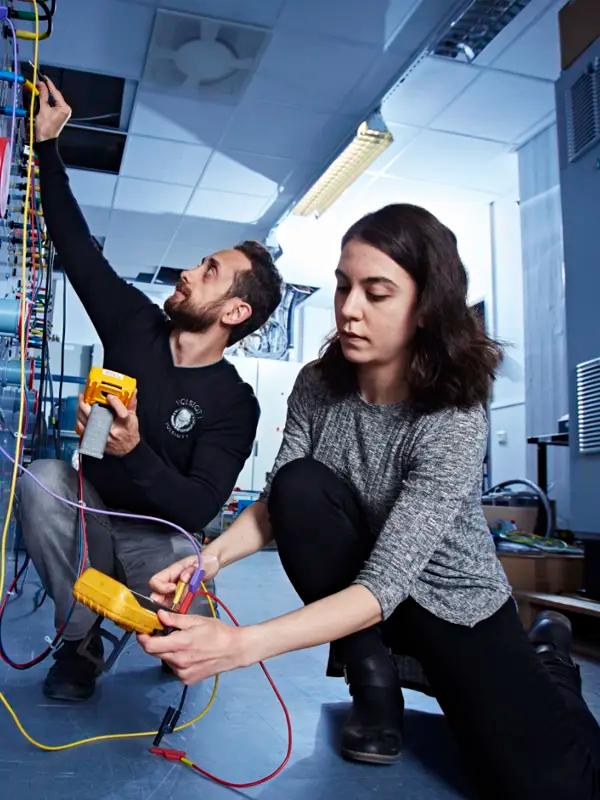 Two persons working in an electrical lab.