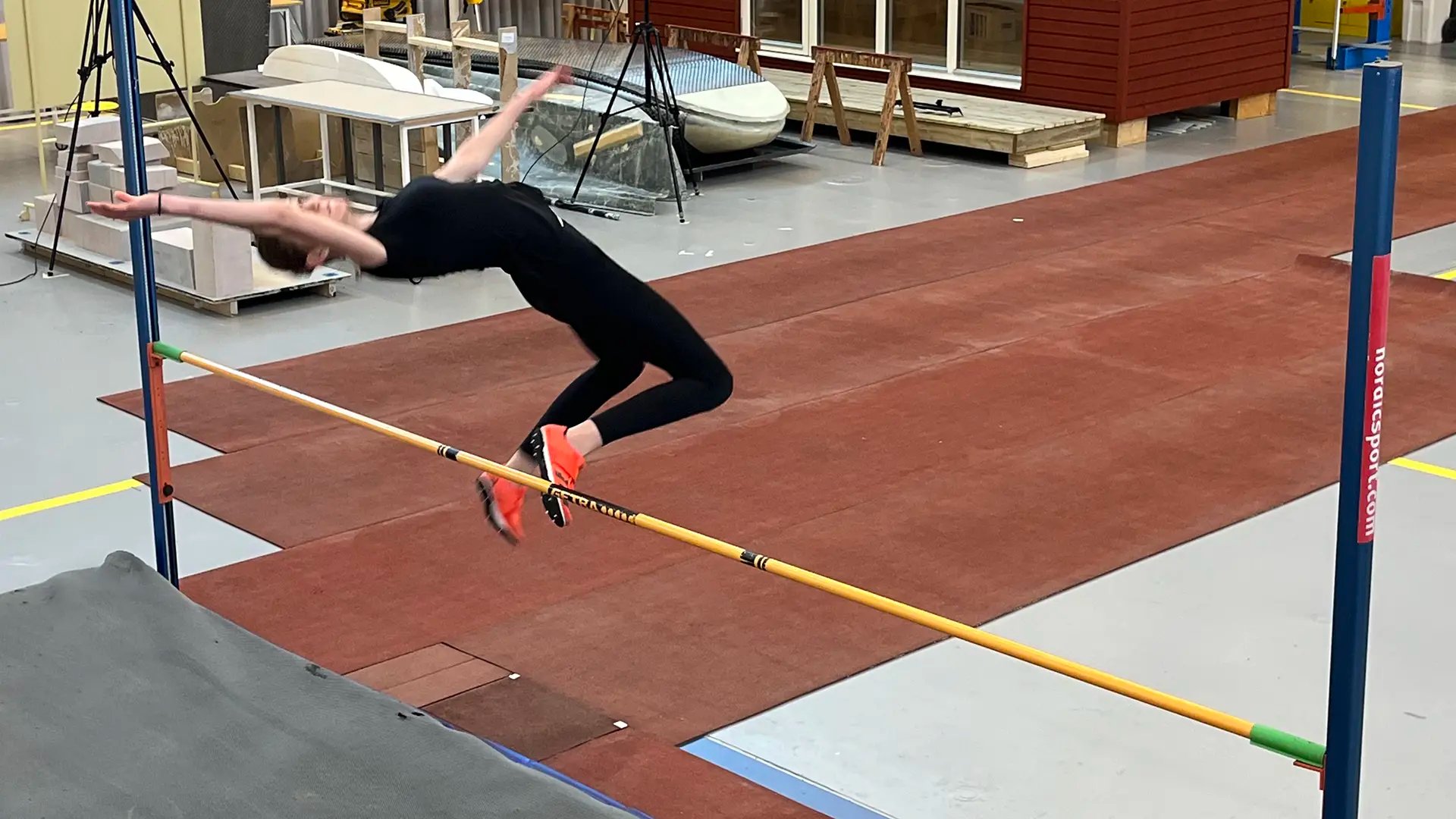 Smilla Arkdal Ranebro, en talangfull junior hoppade höjdhopp med avstamp på kraftplattor i golvet och med IMU-mätare på sig, vilket står för Inertial measurement unit (IMU) och den mäter bland annat acceleration och vinklar på hopparens kropp.