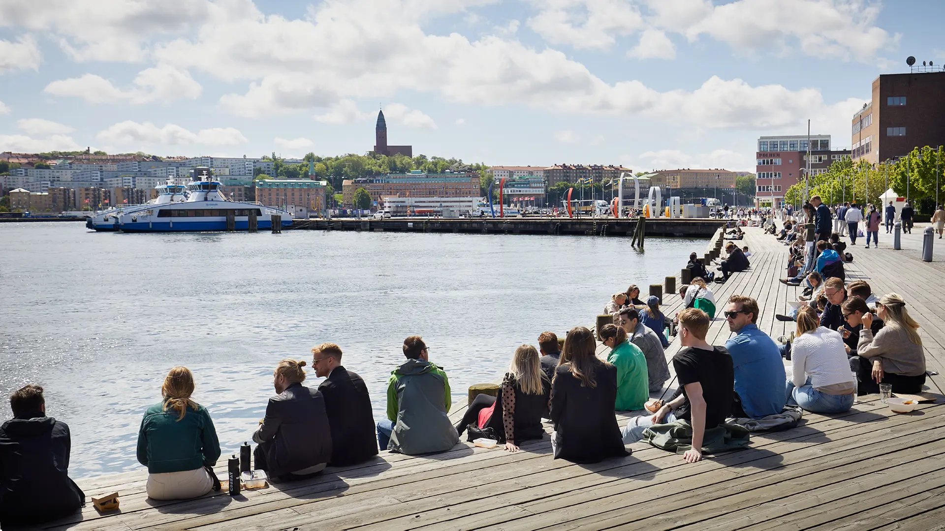 Students sitting on wooden seating area at Lindholmen