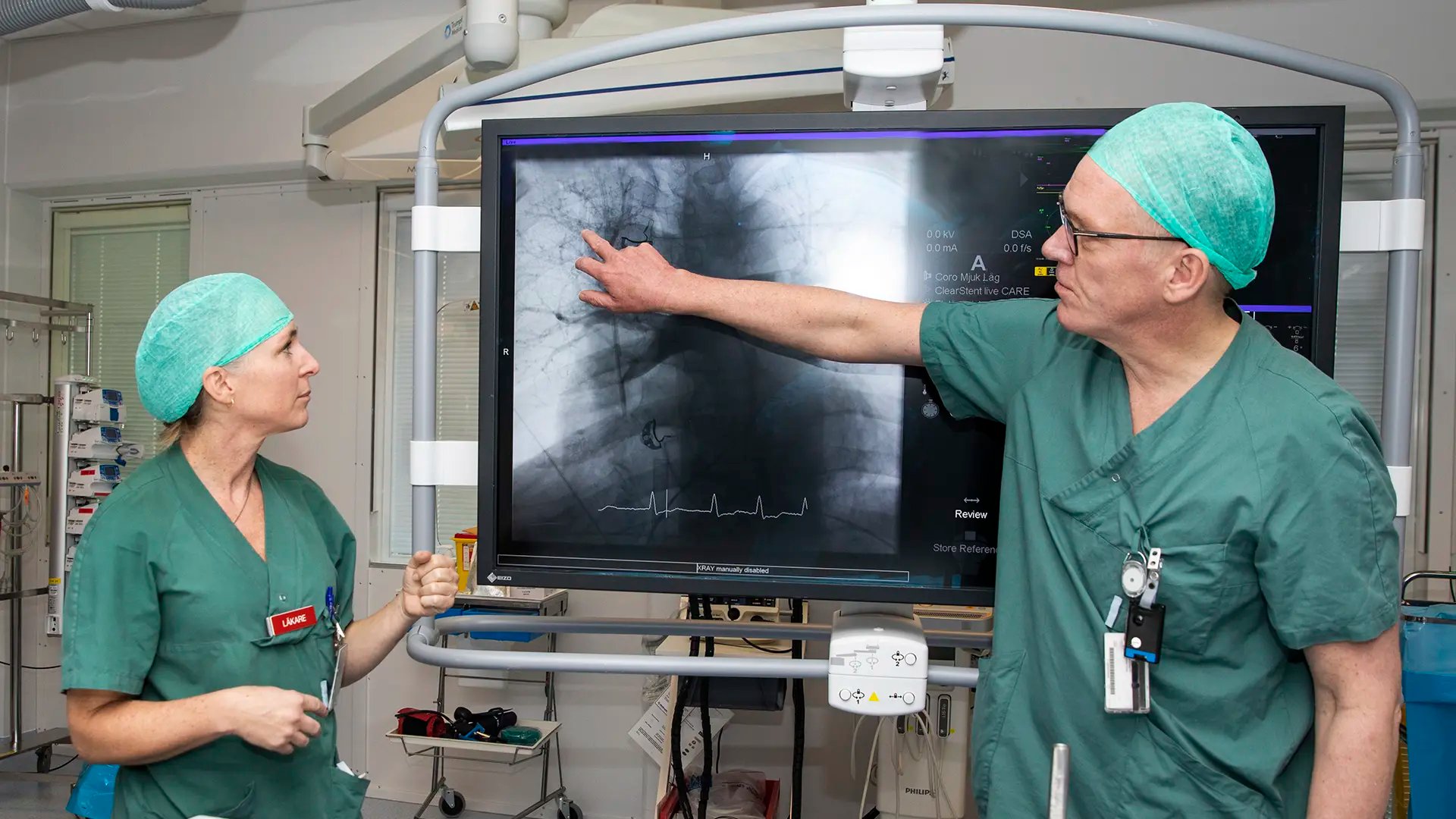 Två läkare pekar på och diskuterar en röntgenbild. 